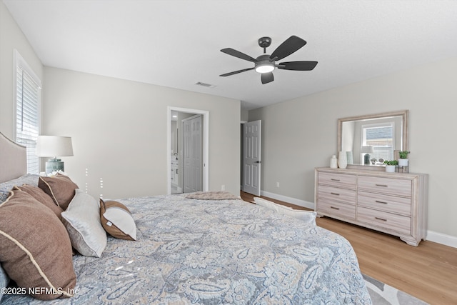 bedroom with multiple windows, visible vents, light wood-type flooring, and baseboards