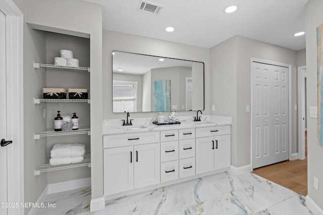 full bath with baseboards, visible vents, and a sink