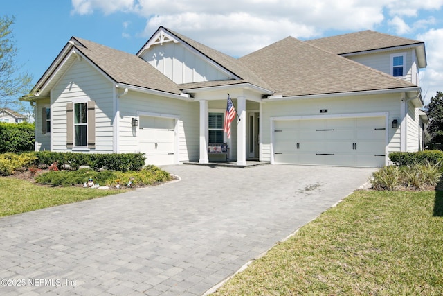 83 Village Grande Dr, Ponte Vedra, FL 32081 - view of front of home with board and batten siding, a shingled roof, a front lawn, decorative driveway, and a garage