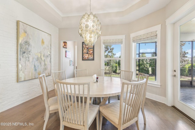 83 Village Grande Dr, Ponte Vedra, FL 32081 - dining area with a chandelier, brick wall, a raised ceiling, and wood finished floors