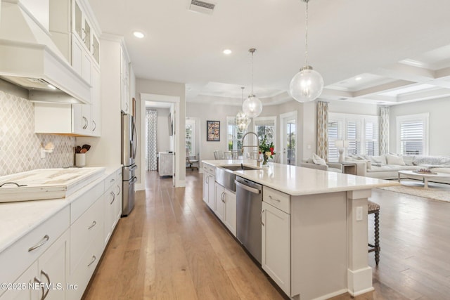 83 Village Grande Dr, Ponte Vedra, FL 32081 - kitchen featuring custom exhaust hood, light wood finished floors, appliances with stainless steel finishes, and a sink