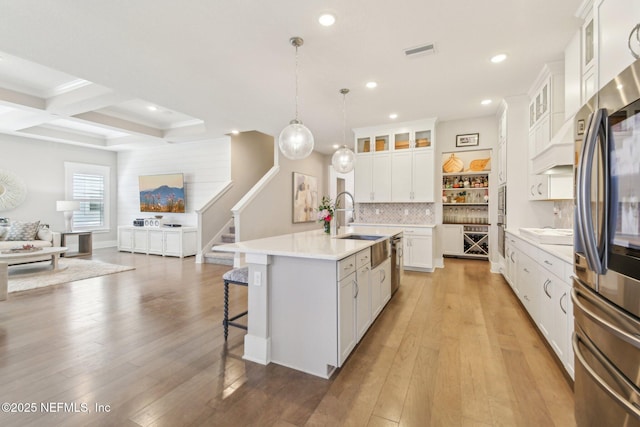 83 Village Grande Dr, Ponte Vedra, FL 32081 - kitchen featuring a kitchen bar, open floor plan, light wood-style floors, appliances with stainless steel finishes, and decorative backsplash
