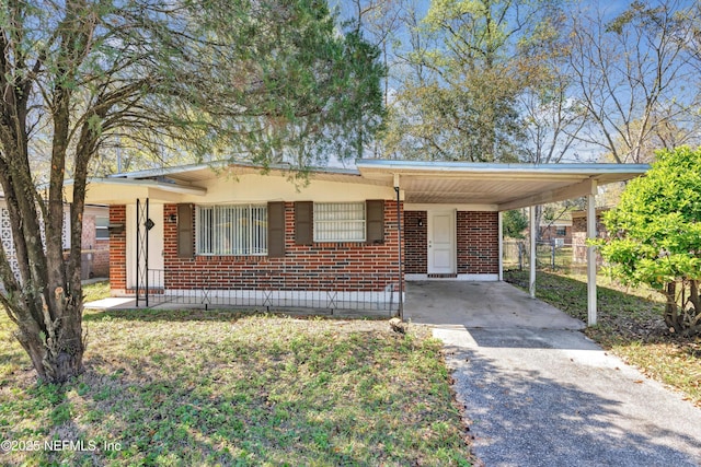 ranch-style house featuring brick siding, an attached carport, driveway, and fence