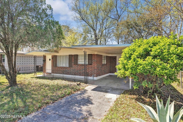 view of front of home featuring an attached carport, concrete driveway, and brick siding