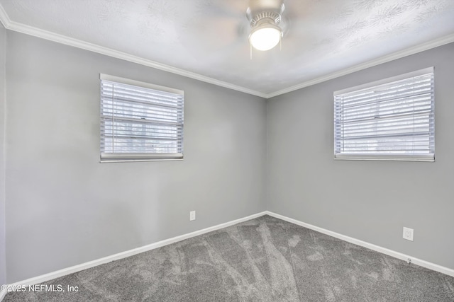 carpeted empty room featuring crown molding, plenty of natural light, baseboards, and ceiling fan