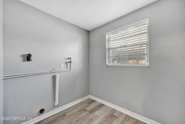 clothes washing area featuring baseboards, laundry area, hookup for a washing machine, wood finished floors, and electric dryer hookup