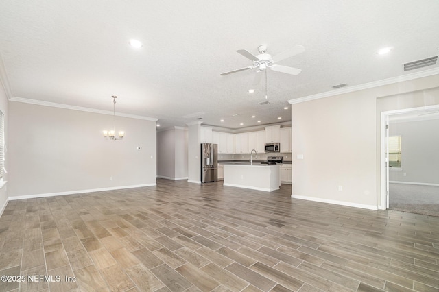 unfurnished living room with light wood-style floors, ceiling fan with notable chandelier, visible vents, and a sink