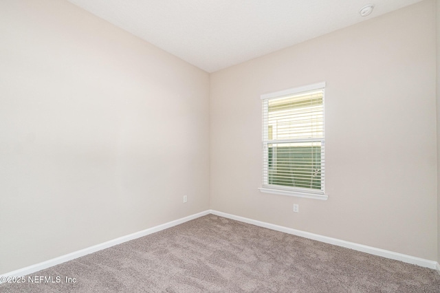 empty room featuring baseboards and carpet flooring