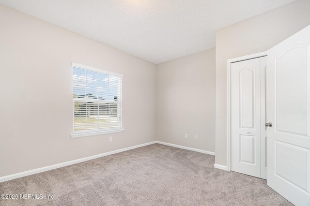 unfurnished bedroom featuring carpet flooring and baseboards