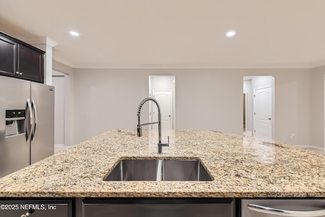 kitchen featuring a sink, appliances with stainless steel finishes, ornamental molding, light stone countertops, and recessed lighting