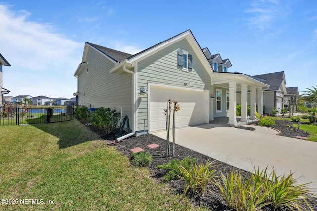 view of home's exterior with a garage, a lawn, driveway, and fence