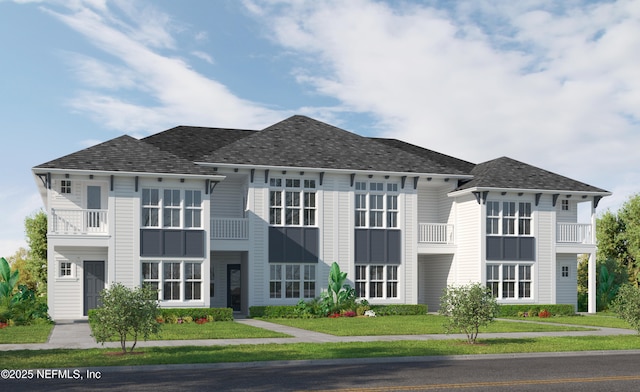 view of front facade with a front lawn and a shingled roof