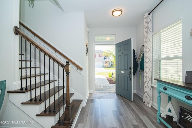 entryway featuring stairway, baseboards, and wood finished floors