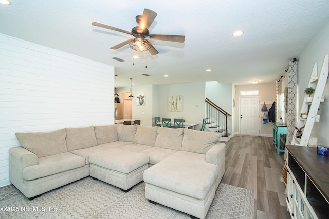 living area with stairway, visible vents, light wood-style flooring, recessed lighting, and ceiling fan