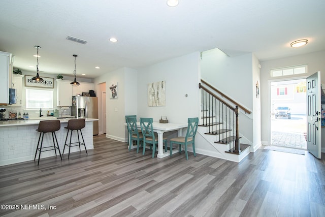 interior space with visible vents, baseboards, stairs, recessed lighting, and light wood-style flooring