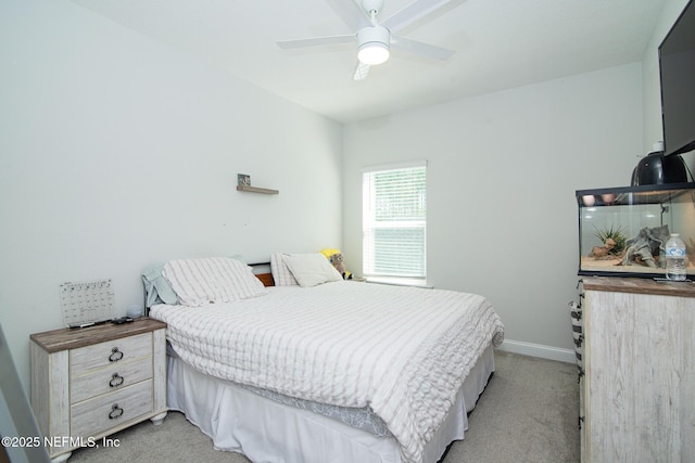 bedroom featuring light carpet, a ceiling fan, and baseboards