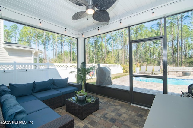 sunroom featuring rail lighting and a ceiling fan