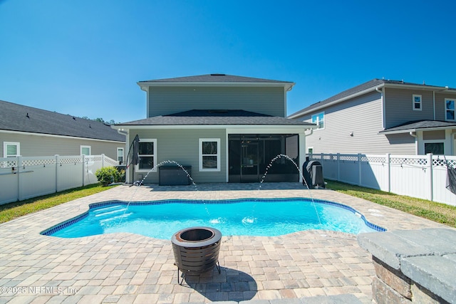 view of swimming pool featuring a patio area, a fenced in pool, a fenced backyard, and a sunroom