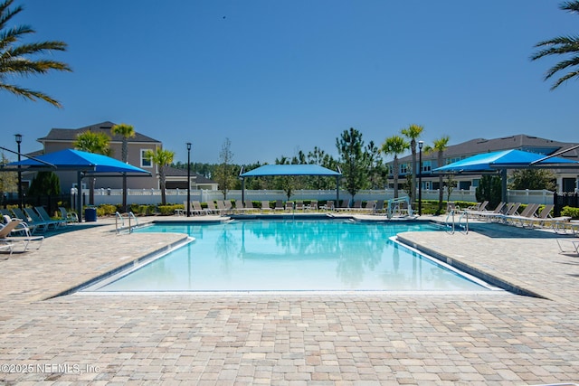 pool with a patio and fence