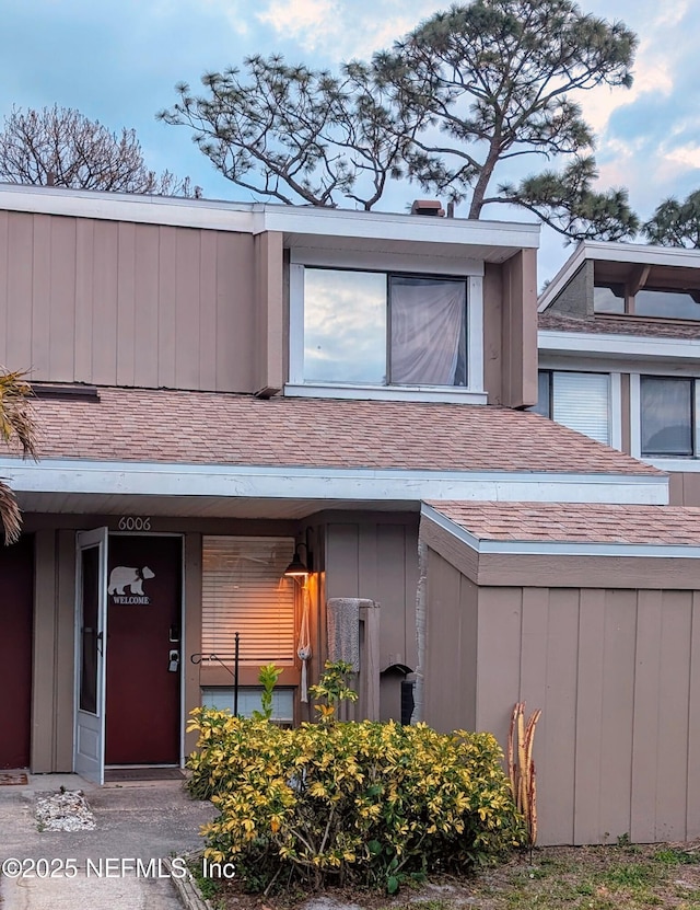 view of exterior entry with a shingled roof