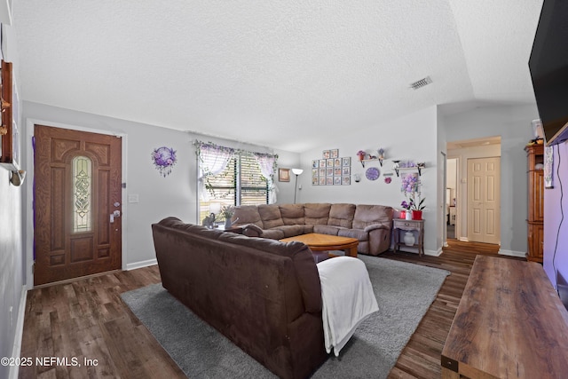 living room with visible vents, a textured ceiling, wood finished floors, and vaulted ceiling