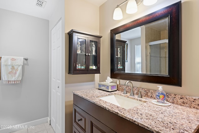 bathroom with vanity, baseboards, visible vents, and tile patterned flooring