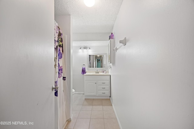 bathroom featuring vanity, baseboards, tile patterned flooring, a textured ceiling, and toilet