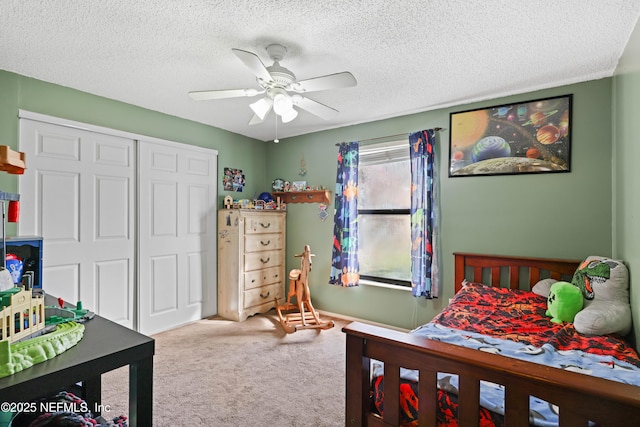 bedroom featuring a closet, carpet flooring, a textured ceiling, and ceiling fan