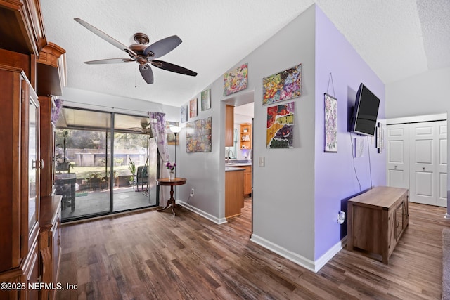 interior space with dark wood-type flooring, a ceiling fan, and a textured ceiling