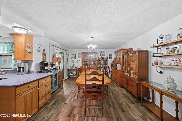 dining room with dark wood-type flooring, an inviting chandelier, and a textured ceiling