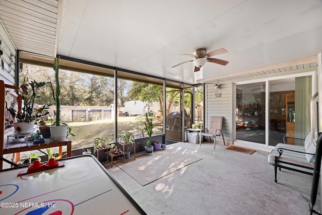 unfurnished sunroom with a ceiling fan