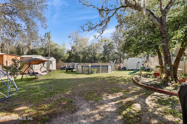 view of yard featuring an outbuilding, a storage shed, and a playground