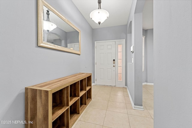 foyer featuring light tile patterned floors and baseboards