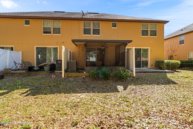 rear view of house with stucco siding, a ceiling fan, fence, cooling unit, and a patio area