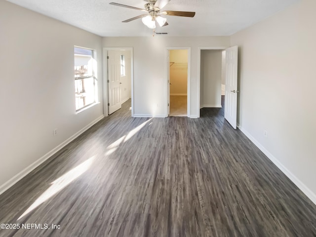 unfurnished bedroom featuring baseboards, visible vents, dark wood-style flooring, and a textured ceiling