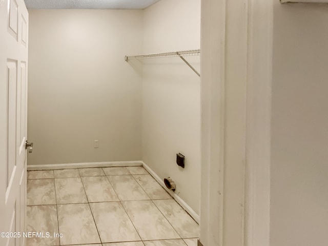 laundry room with light tile patterned flooring, laundry area, and baseboards