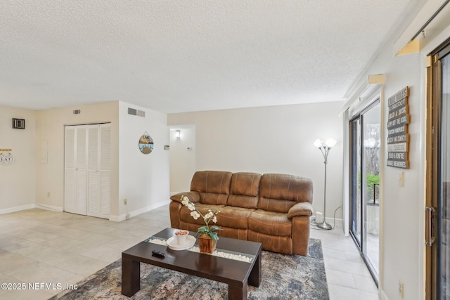 5400 La Moya Ave Unit 16, Jacksonville, FL 32210 - living area with light tile patterned floors, baseboards, visible vents, and a textured ceiling