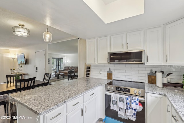 5400 La Moya Ave Unit 16, Jacksonville, FL 32210 - kitchen with white cabinetry, a peninsula, tasteful backsplash, and appliances with stainless steel finishes