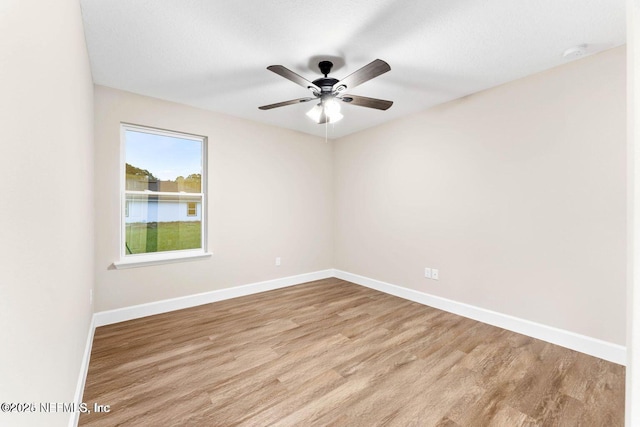 spare room with ceiling fan, baseboards, and wood finished floors