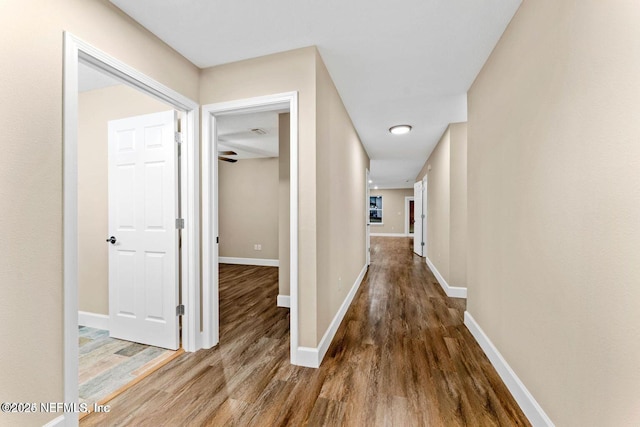 hallway featuring baseboards and wood finished floors