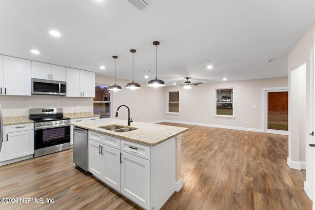 kitchen with light wood finished floors, visible vents, appliances with stainless steel finishes, white cabinets, and a sink