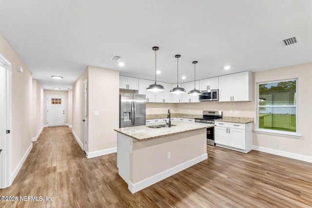 kitchen featuring visible vents, appliances with stainless steel finishes, light wood-type flooring, and a sink