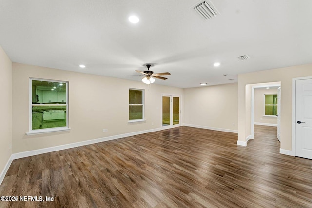 spare room featuring visible vents, baseboards, and wood finished floors