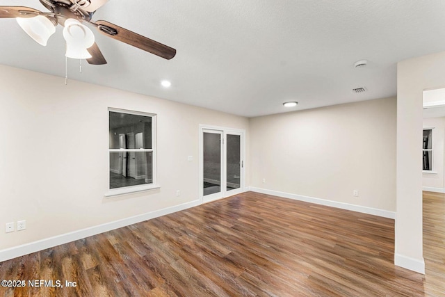 empty room featuring visible vents, baseboards, wood finished floors, and a ceiling fan