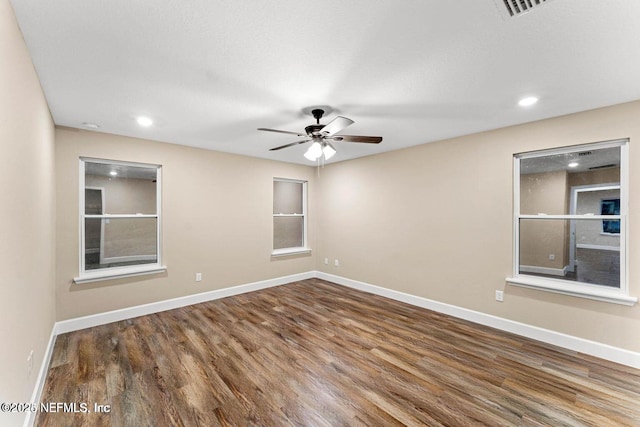 empty room with recessed lighting, ceiling fan, baseboards, and wood finished floors