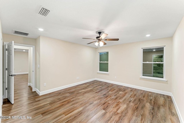 spare room with visible vents, recessed lighting, baseboards, and wood finished floors