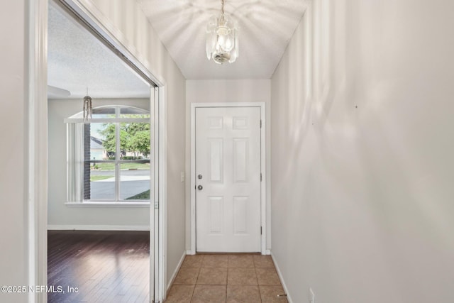 2721 Ridge Haven Dr, Green Cove Springs, FL 32043 - doorway to outside featuring baseboards, a notable chandelier, tile patterned floors, and a textured ceiling