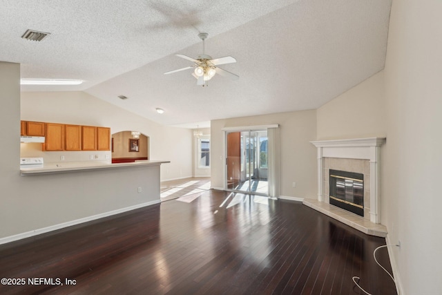 2721 Ridge Haven Dr, Green Cove Springs, FL 32043 - unfurnished living room featuring vaulted ceiling, dark wood-type flooring, baseboards, ceiling fan, and a tile fireplace