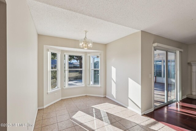 2721 Ridge Haven Dr, Green Cove Springs, FL 32043 - unfurnished dining area with tile patterned floors, baseboards, a chandelier, and a textured ceiling