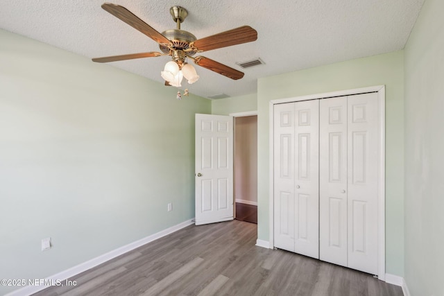 2721 Ridge Haven Dr, Green Cove Springs, FL 32043 - unfurnished bedroom with a closet, wood finished floors, a textured ceiling, baseboards, and visible vents